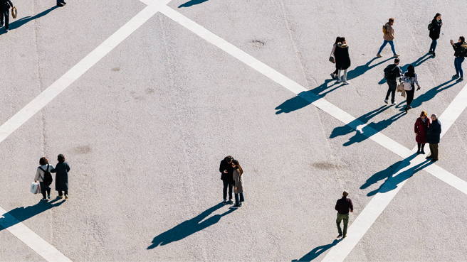 Aerial view of people walking across an open concrete space