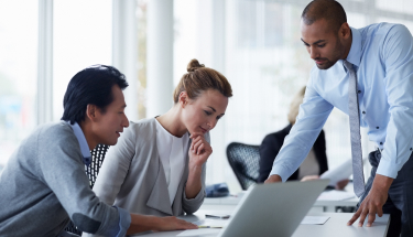Three people in business attire working in an office