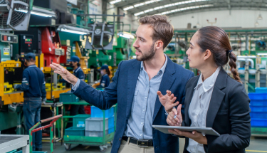 Two businesspeople talking in a factory
