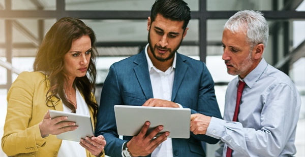 Three business people looking at a tablet