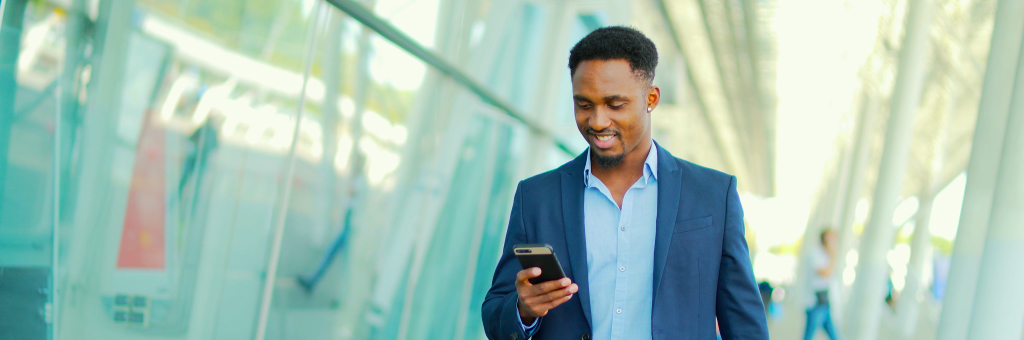 man walking and looking at his phone
