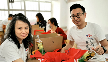 Hunger relief: A man and a woman packaging up food in boxes