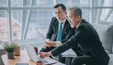 Two businessmen working on a computer