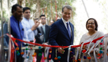 Bank of America CEO Brian Moynihan cutting a ribbon while standing next to India Country Head Kaku Nakhate