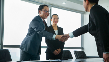 A group of people in business attire shaking hands
