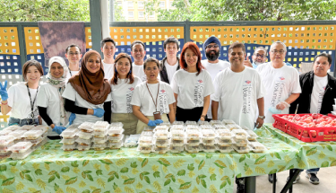 A group of volunteers behind a table of packaged foods