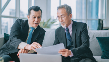 Two businessmen looking over a report 