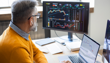 Man looking at a screen with charts 