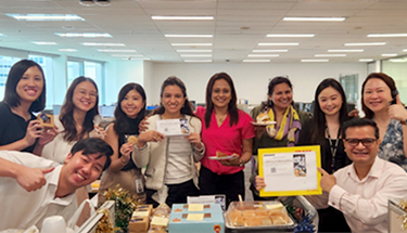 A group of employees holding Food Drive props