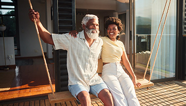 A happy couple sitting on a swing together