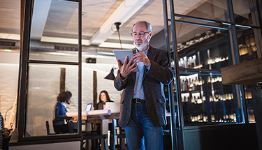 A businessman referring to the screen of his tablet
