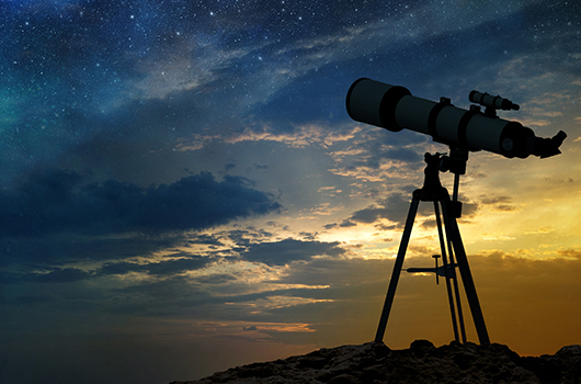 A telescope searching the sky at dusk