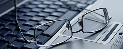Glasses sitting on keyboard of laptop