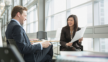 Smiling businesspeople reviewing paperwork together