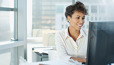 A businesswoman sitting at a desk working on a computer