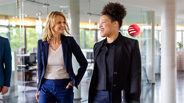 two people walking and talking at work