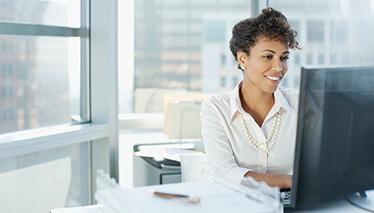 A businesswoman sitting at a desk working on a computer