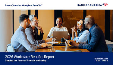 Three men and two women smiling and laughing in a meeting in a work conference room.