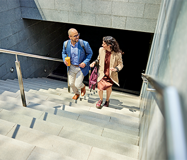 Man and woman walking up the stairs outside